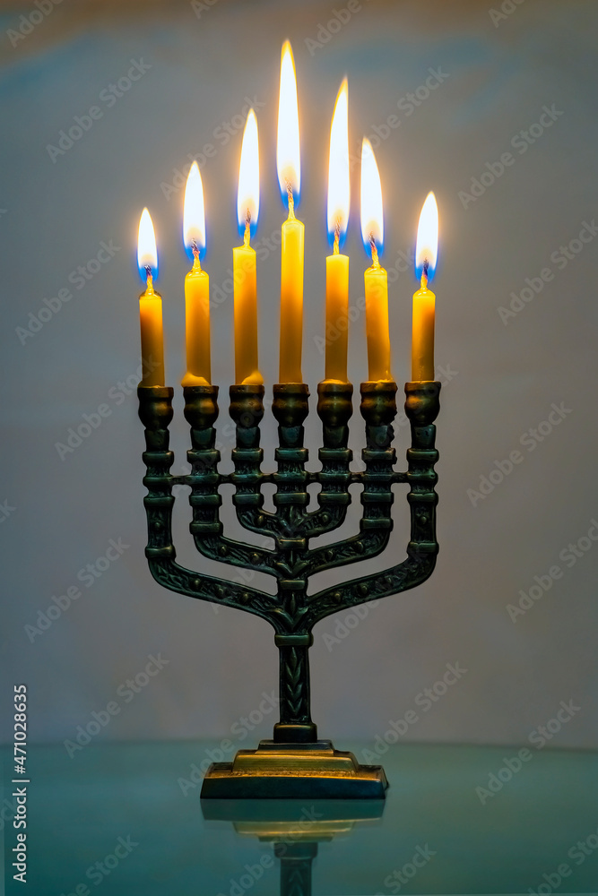 Hanukkah menorah closeup with burning candles for holiday card background. Retro old style hanukkah holiday. The Menorah is the oldest symbol of Judaism. Hanukkah festive attribute. Hanukkah menorah closeup with burning candles for holiday card background. Retro old style hanukkah holiday. The Menorah is the oldest symbol of Judaism. Hanukkah festive attribute.