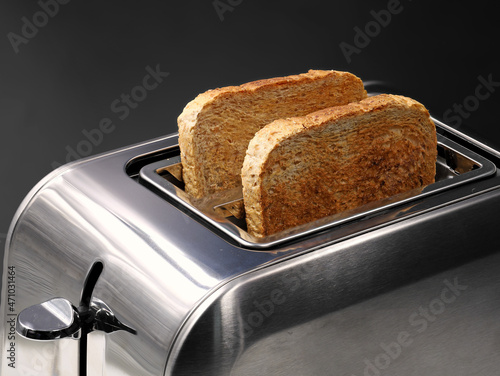 chrom toaster with wholemeal bread slices isolated on black background