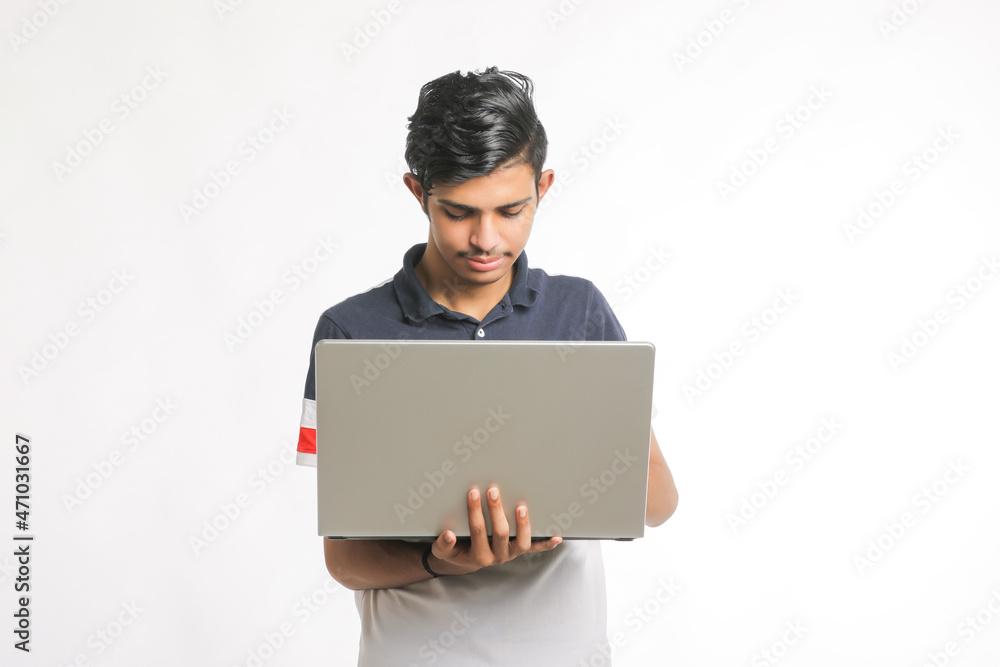 Young indian man using laptop over white background. Young indian man using laptop over white background.