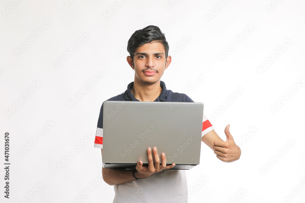 Young indian man using laptop over white background. Young indian man using laptop over white background.