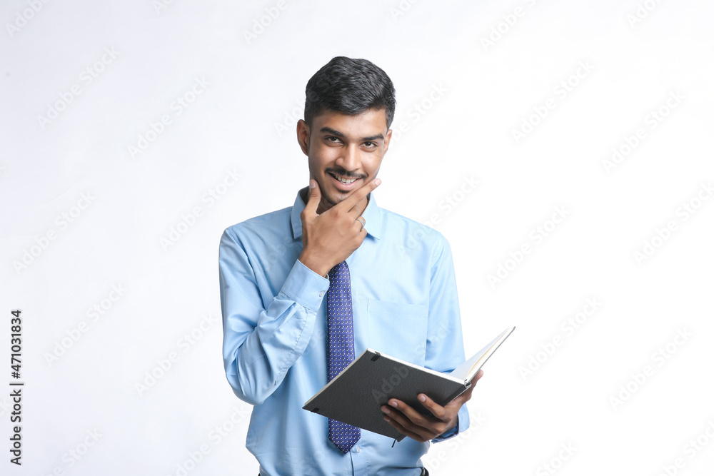 Young indian businessman cheaking or reading dairy on white background. Young indian businessman cheaking or reading dairy on white background.