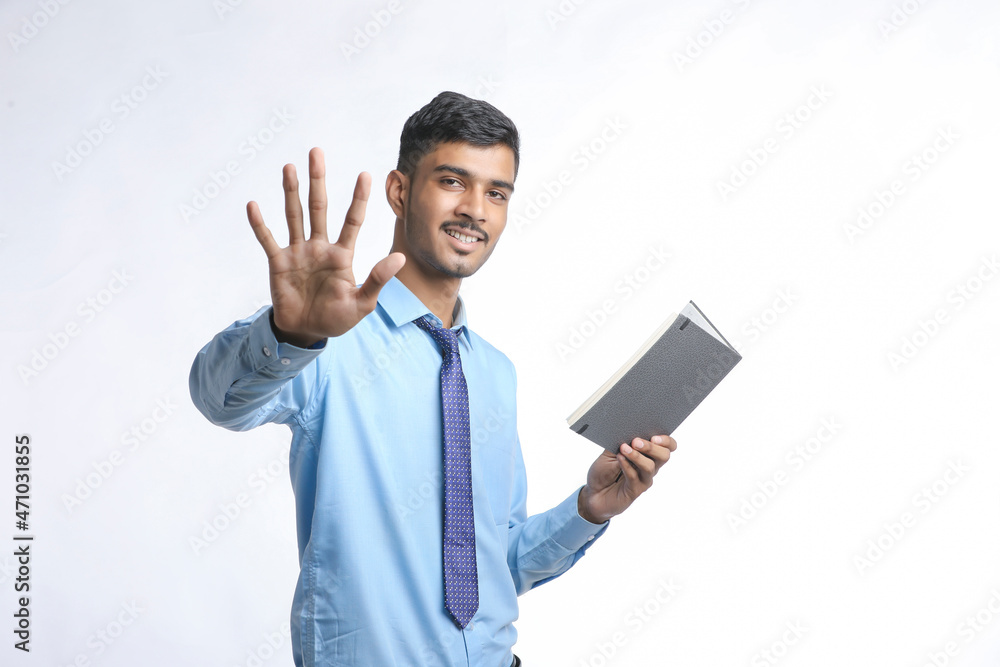 successful Young Indian businessman or employee wearing Suit and cheaking dairy on white background. successful Young Indian businessman or employee wearing Suit and cheaking dairy on white background.