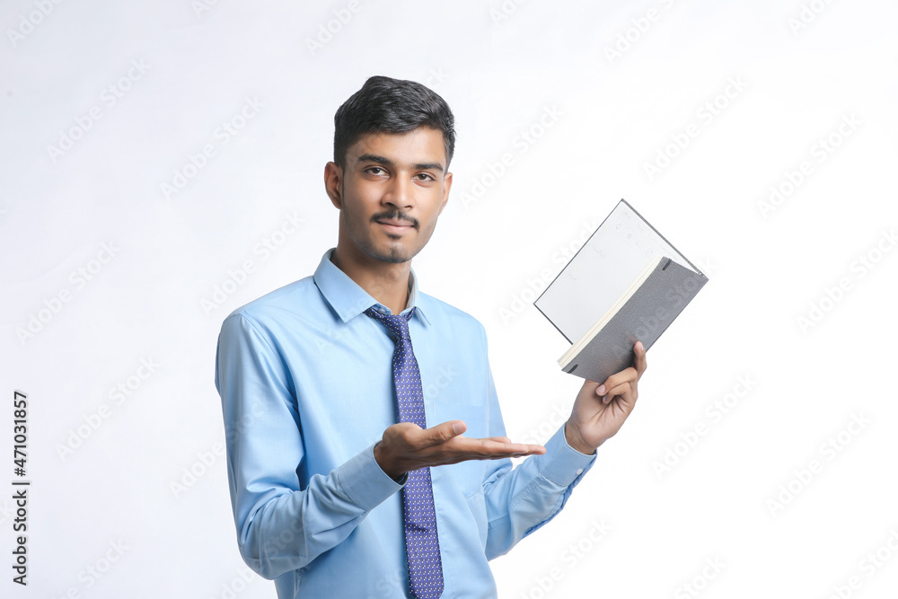 successful Young Indian businessman or employee wearing Suit and cheaking dairy on white background. successful Young Indian businessman or employee wearing Suit and cheaking dairy on white background.