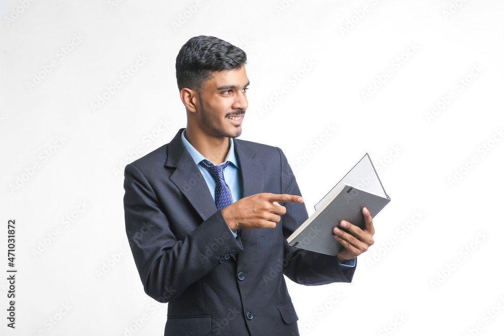 successful Young Indian businessman or employee wearing Suit and cheaking dairy on white background. successful Young Indian businessman or employee wearing Suit and cheaking dairy on white background.