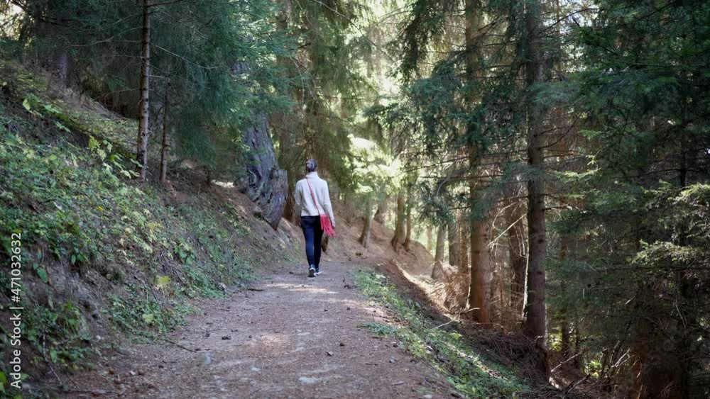 Woman walks alone in the mountain path. Slow motion 4K Woman walks alone in the mountain path. Slow motion 4K