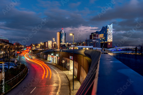 Blue hour in the port of Hamburg with the illuminated Elbphilharmonie and traffic in motion in November 2021