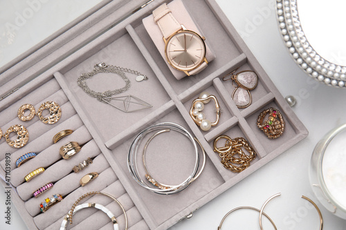 Elegant jewelry box with beautiful bijouterie on white table, flat lay