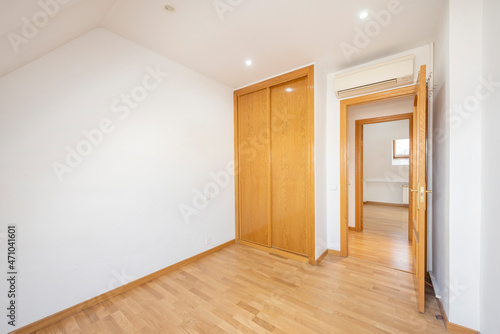 Bedroom with air conditioning and built-in wardrobe on the attic floor of an urban building