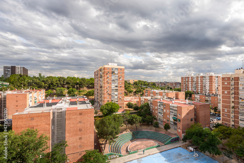 Fototapeta Naklejka Na Ścianę i Meble -  Views of an urban housing area with an amphitheater and basketball courts one day with threatening rain clouds