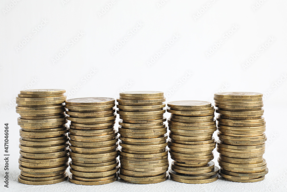 Many coins stacked on white table, space for text Many coins stacked on white table, space for text