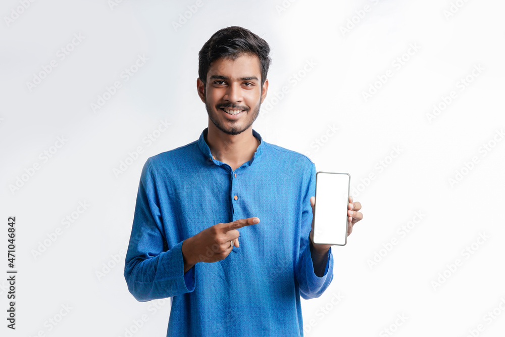 Young indian man in tradition wear and showing smartphone screen on white background. Young indian man in tradition wear and showing smartphone screen on white background.