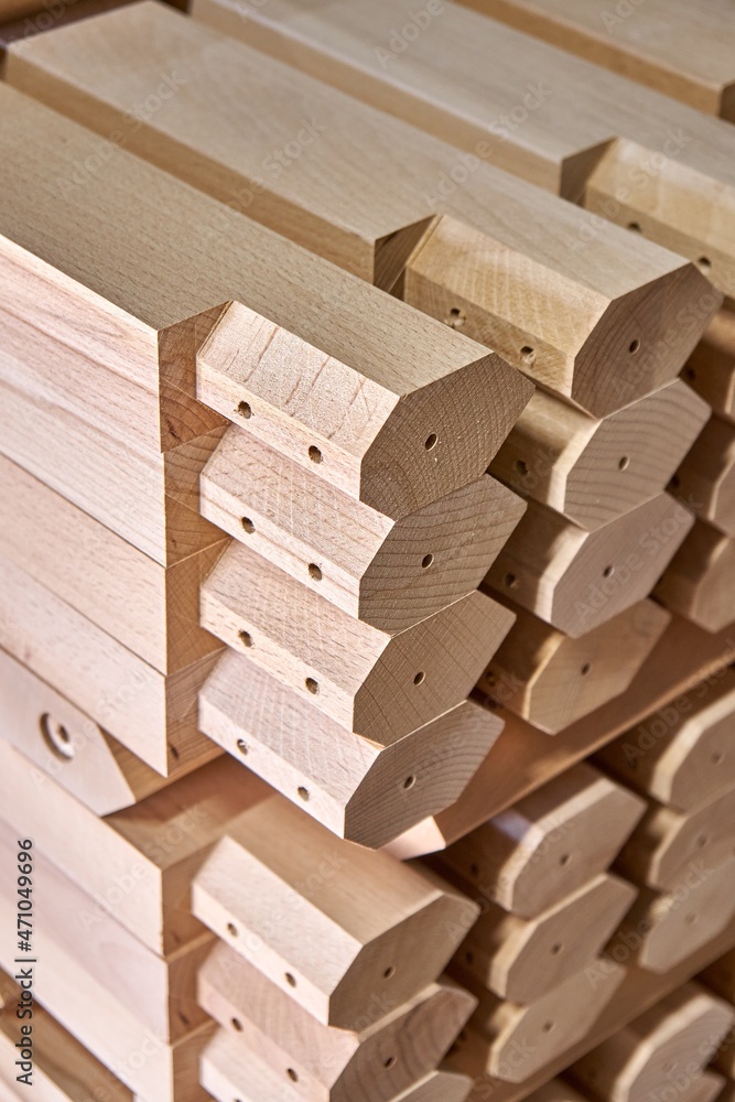 Huge stack of simple tables legs made of solid beechwood material stands in contemporary carpentry workshop extreme closeup Huge stack of simple tables legs made of solid beechwood material stands in contemporary carpentry workshop extreme closeup