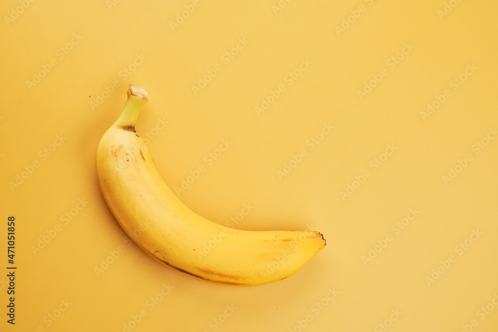 Whole banana with peel isolated on yellow background with copy space, top view, clipping path Whole banana with peel isolated on yellow background with copy space, top view, clipping path