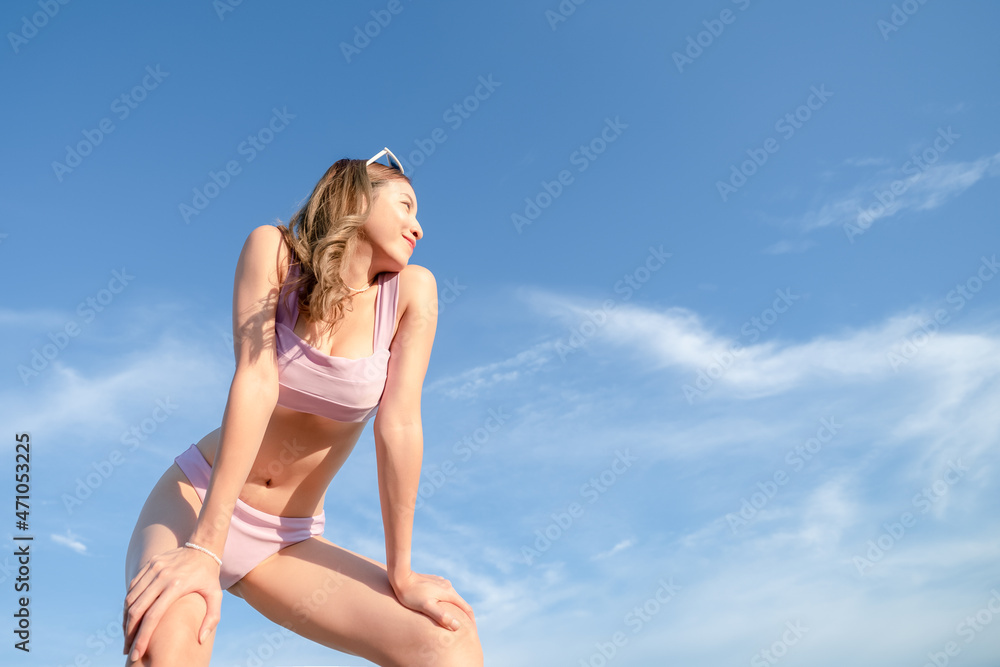 Portrait of woman in purple bikini swimwear with sky background. Summer vacation. Portrait of woman in purple bikini swimwear with sky background. Summer vacation.