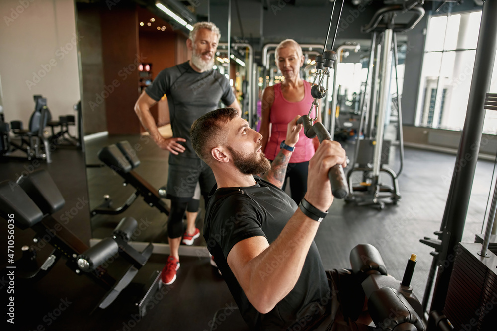 Athletic trainer demonstrates how to use power lifting gym equipment Athletic trainer demonstrates how to use power lifting gym equipment