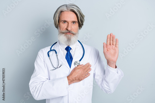 Photo of faithful doc man show swear sign promise stop covid pandemic hippocratic oath isolated over grey color background photo