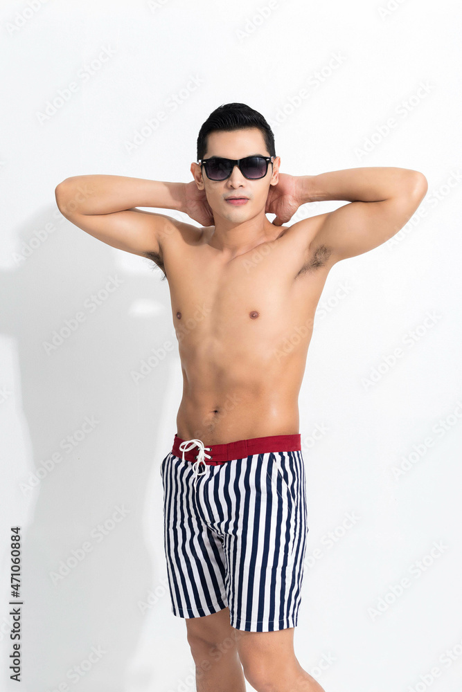 Fototapeta premium Man in striped beach shorts sunbathing.
