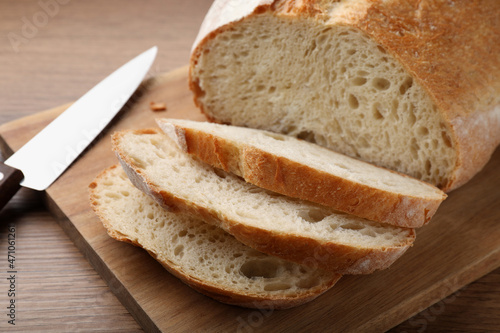Cut tasty wheat sodawater bread on wooden table, closeup