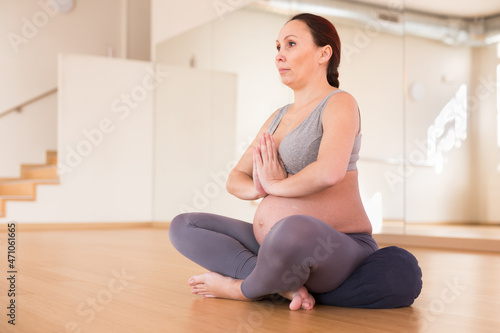 Pregnant woman is engaged in yoga. Easy pose or sukhasana