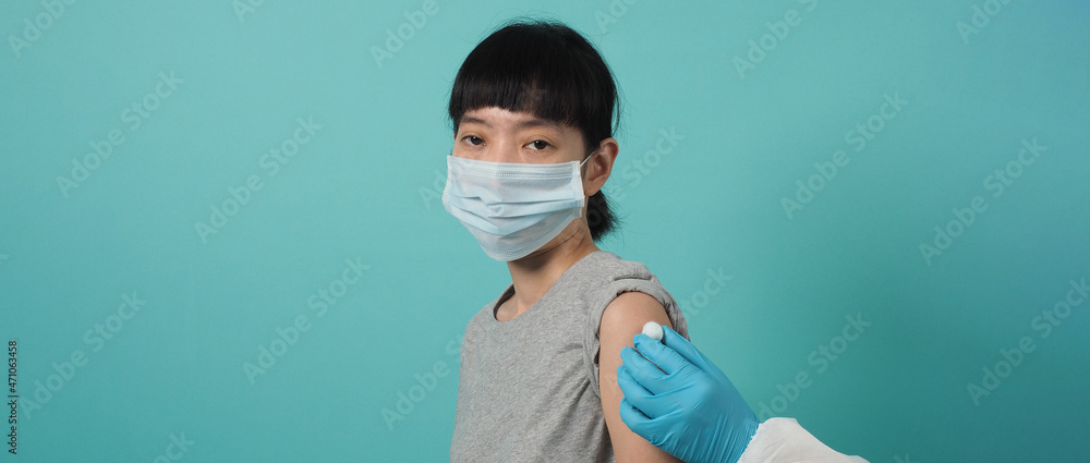 Vaccination immunization disease prevention concept. Woman in medical face mask getting Covid 19 or flu vaccine. Doctor using cotton before and after make injection. Coronavirus vaccinated woman. Vaccination immunization disease prevention concept. Woman in medical face mask getting Covid 19 or flu vaccine. Doctor using cotton before and after make injection. Coronavirus vaccinated woman.