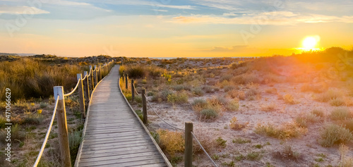 beautiful wooden path to the beach at sunset