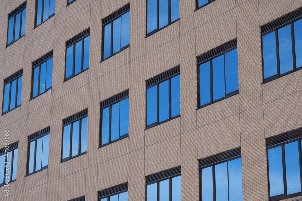 青い空を反射したビルの窓ガラス