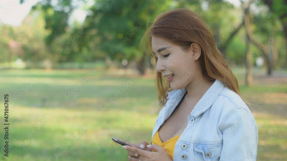 Holiday concept of 4k Resolution. Asian woman playing mobile phone in the garden.