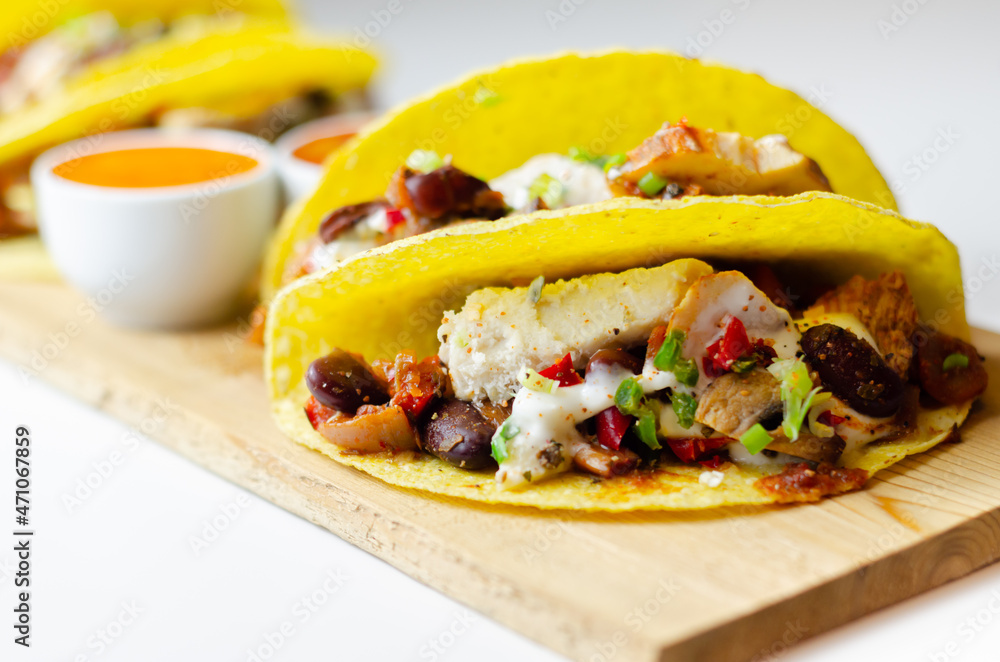 Mexican tacos shells with chicken and red kidney beans, onion, red and green peppers, and salsa sauce Mexican tacos shells with chicken and red kidney beans, onion, red and green peppers, and salsa sauce