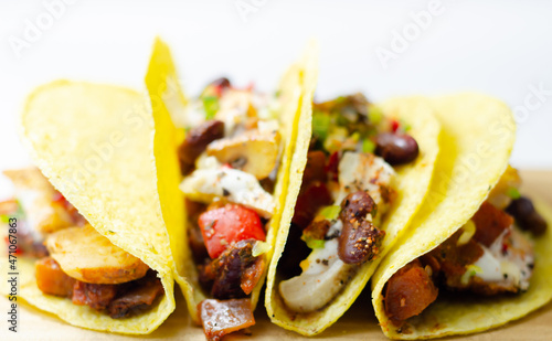 Mexican tacos shells with chicken and red kidney beans, onion,  red and green peppers, and salsa sauce