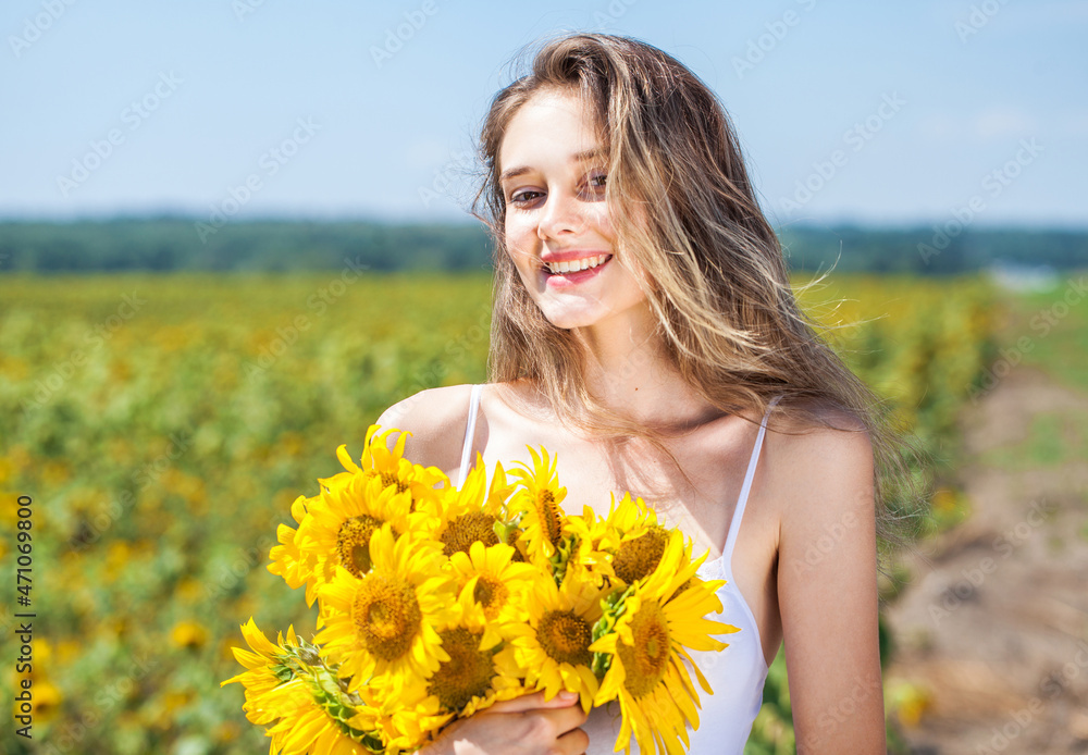 Young beautiful brunette girl with a bouquet of sunflowers