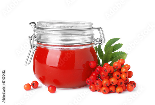 Delicious rowan jam in glass jar and berries with green leaves on white background