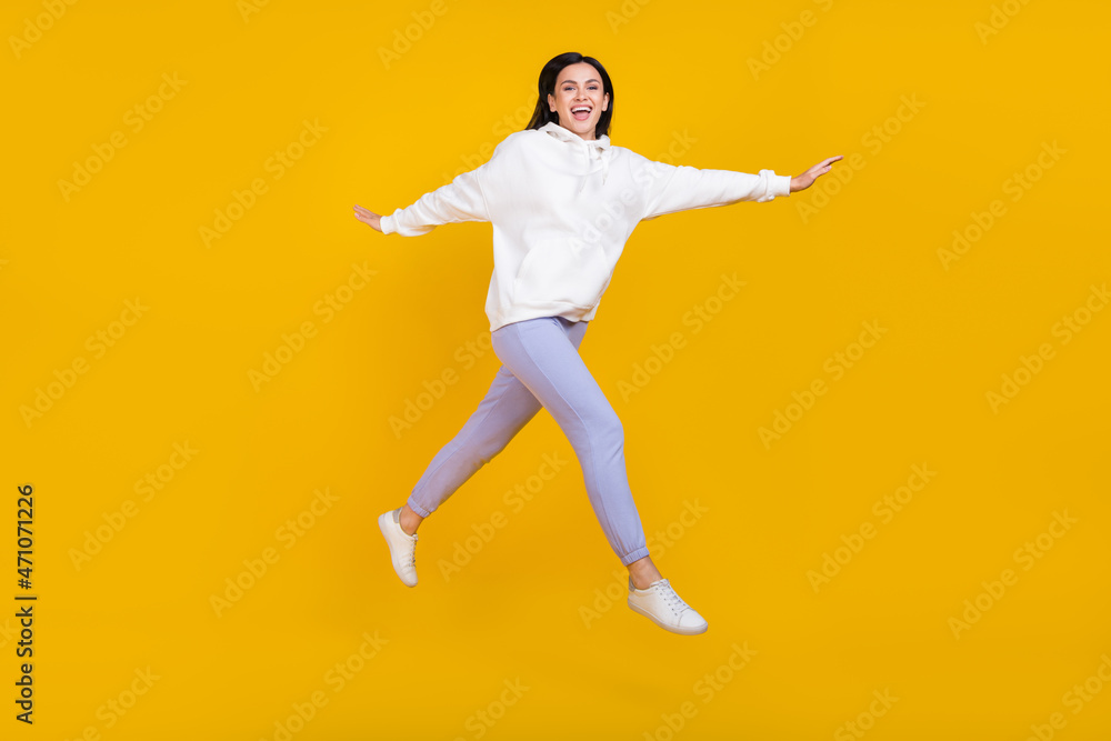 Full body photo of cheerful youth lady jump step stroll isolated over bright yellow color background