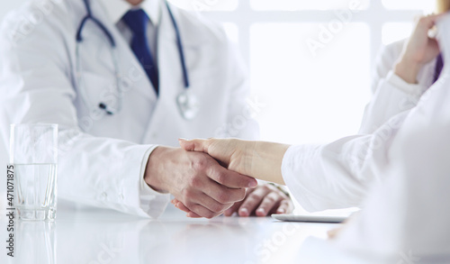 Doctor shaking hands with a male patient in the office