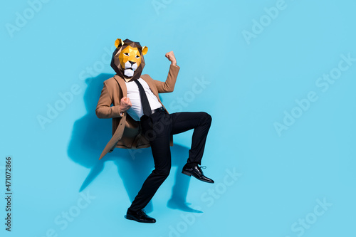 Full length photo of ecstatic guy in lion mask theme festival character win prize raise fists up isolated over blue color background photo