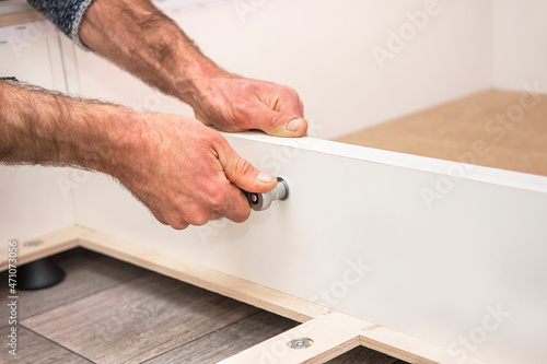 Workers assembling furniture at home. Hands tightening the bolt.