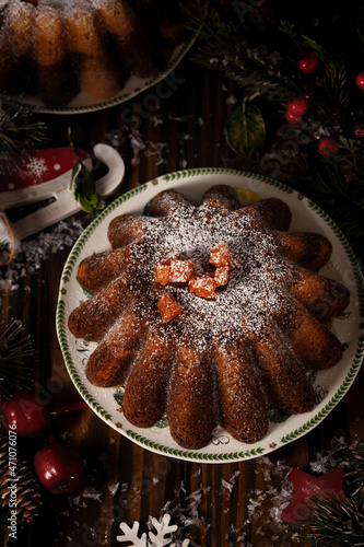 Traditional homemade chocolate christmas cake with orange candied fruits powdering with icing sugar