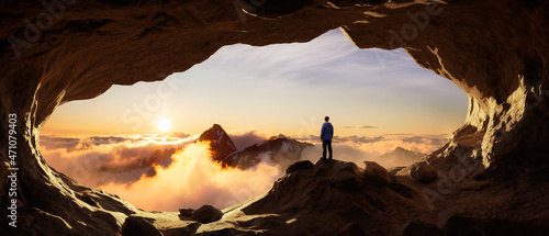 Fototapeta Przygód Mężczyzna Turysta stojący w jaskini z górami skalistymi w tle. Kompozyt przygodowy. Szczyt renderowania 3D. Zdjęcie lotnicze krajobrazu z Kolumbii Brytyjskiej w Kanadzie. Zachód słońca niebo