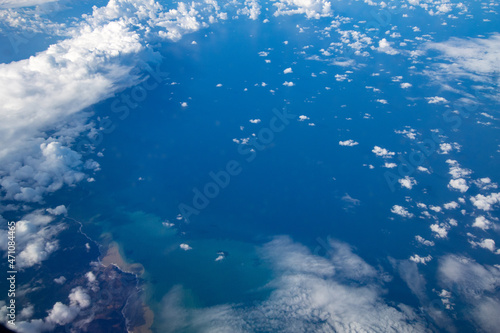 Aerial view from airplane during international flight. Travel in airplane, landscape from above and clouds. © PAOLO