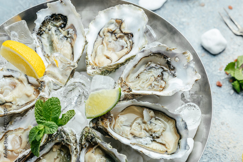 Fresh Oysters with lime, lemon and ice. Restaurant menu, dieting, cookbook recipe photo