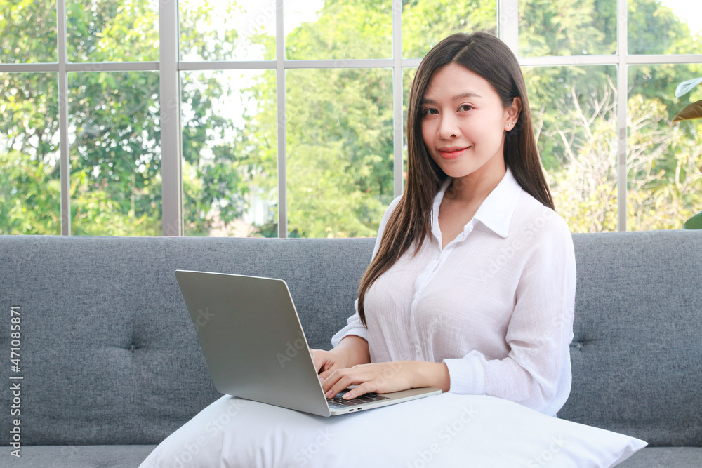 beautiful asian girl Sitting on the sofa in the living room of the house. Work from home concept, freelance beautiful asian girl Sitting on the sofa in the living room of the house. Work from home concept, freelance