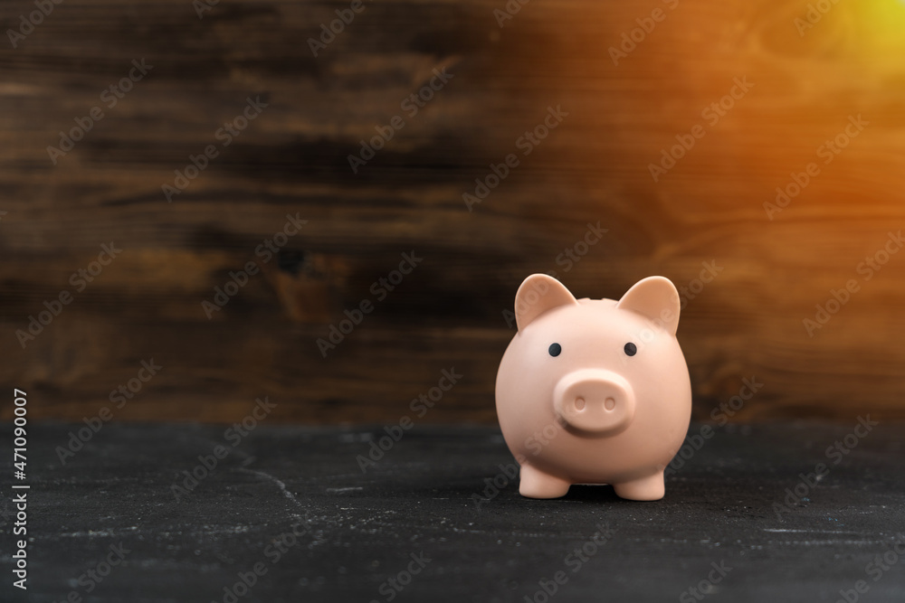 Pink piggy bank on a wooden background, copyspace