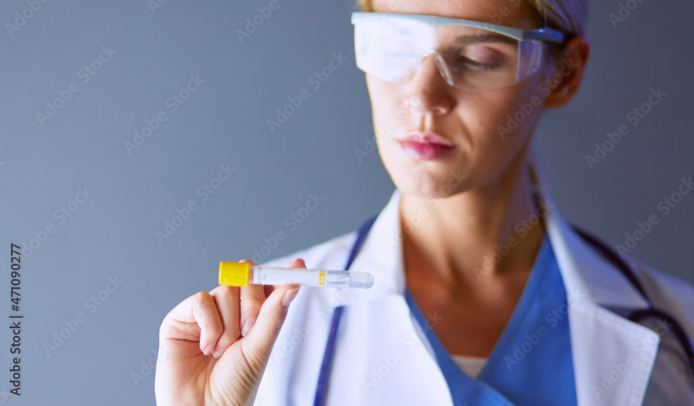 Female medical or research scientist or doctor using looking at a test tube of clear solution in a lab or laboratory. Female medical or research scientist or doctor using looking at a test tube of clear solution in a lab or laboratory.