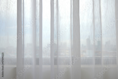 City center viewed through white voile window curtain photo