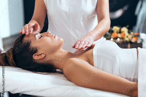 Print op canvas Beautiful young woman having reiki healing treatment in health spa center