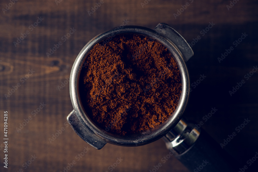 Fresh ground coffee in holder on the rustic wooden background. Selective focus. Shallow depth of field. Fresh ground coffee in holder on the rustic wooden background. Selective focus. Shallow depth of field.