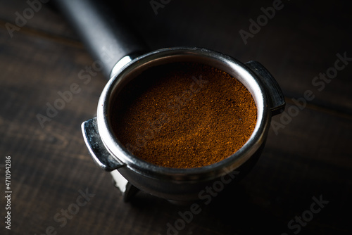 Fresh ground coffee in holder on the rustic wooden background. Selective focus. Shallow depth of field.