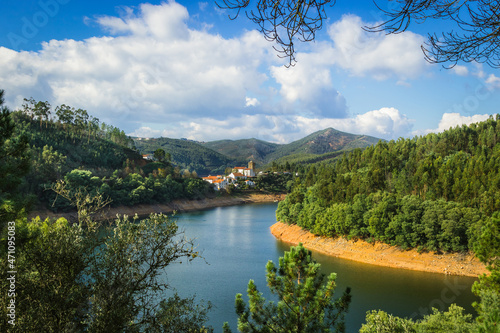 Picturesque village of Dornes in the Zezere river - Portugal. Old church and castle over the river with mountain background photo