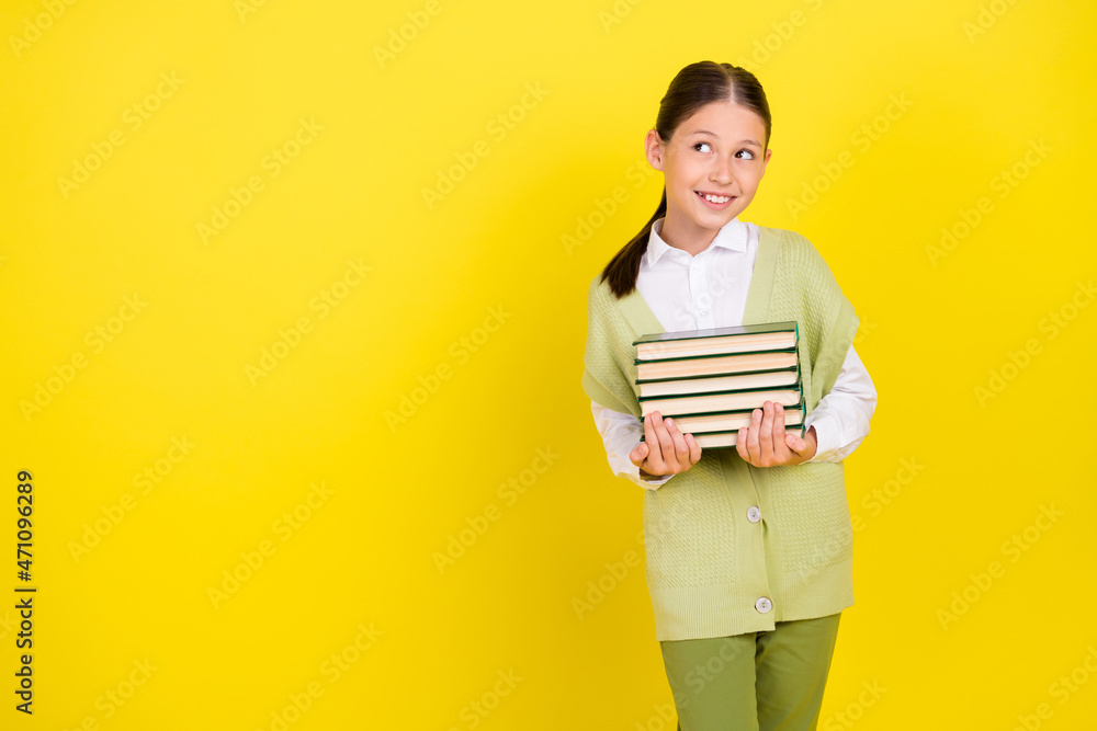 Portrait of attractive smart curious girlish cunning cheerful girl holding book copy space isolated over bright yellow color background Portrait of attractive smart curious girlish cunning cheerful girl holding book copy space isolated over bright yellow color background