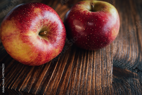Red winter apple ondark wood. Close up from seasonal fruits. Background for healthy nutrion withspace for text photo