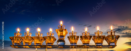 Crystal festive menorah and burning candles with olive oil as symbol of Hanuk...